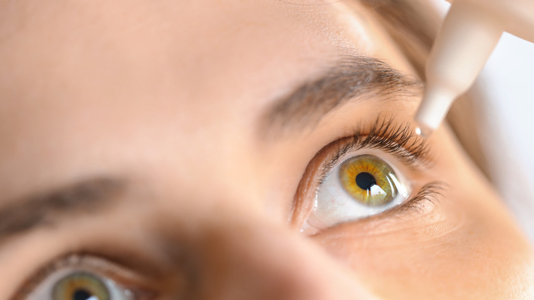 Woman applying eye drops 