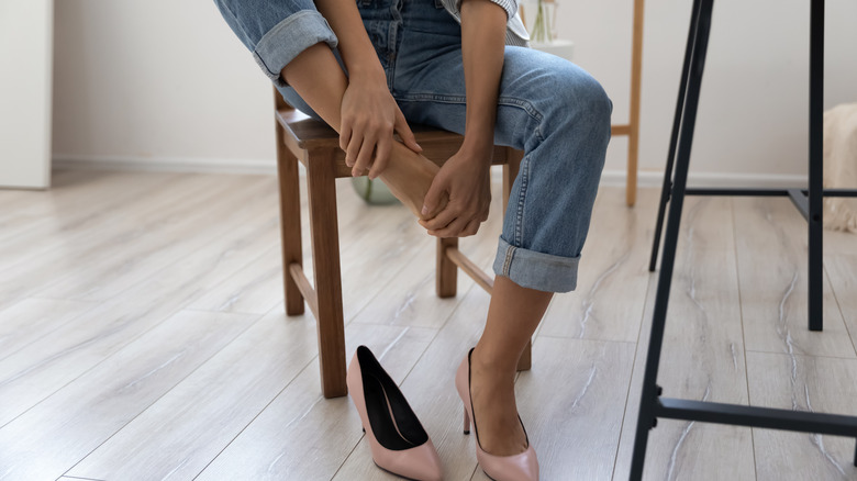 A woman rubs her foot