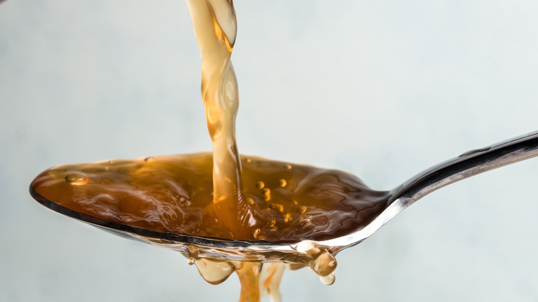 Apple cider vinegar poured onto spoon