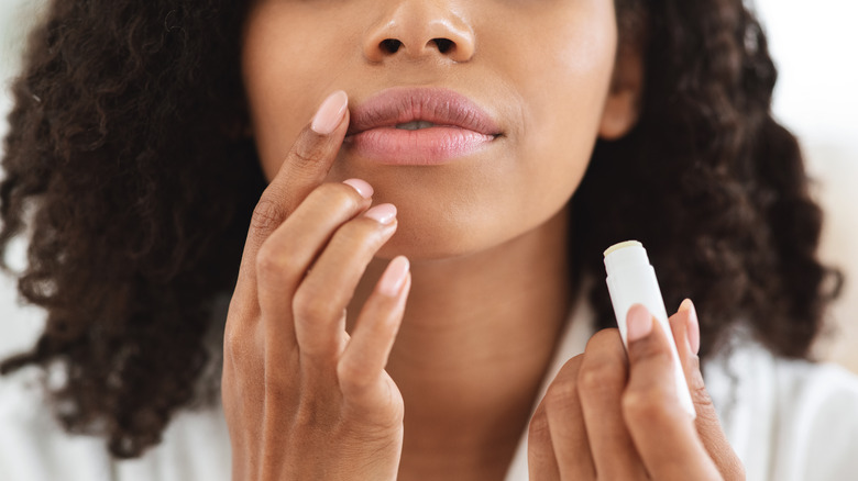 Woman applying lip balm