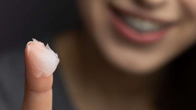 Petroleum jelly on woman's finger