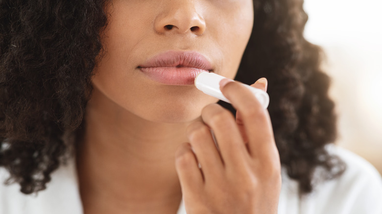 Woman applying lip balm