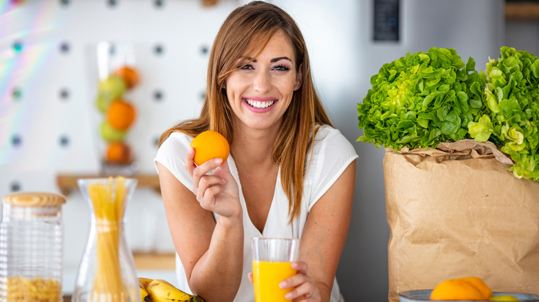 Woman preparing fresh squeezed orange juice