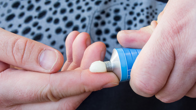 Patient squeezes medicine from a tube