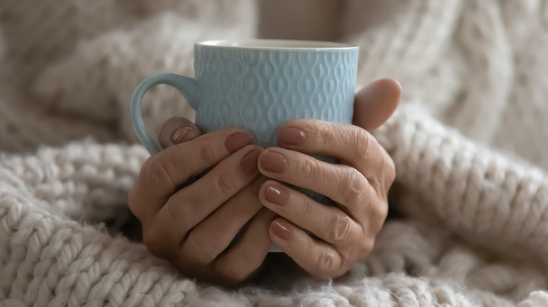Hands holding a cup of tea