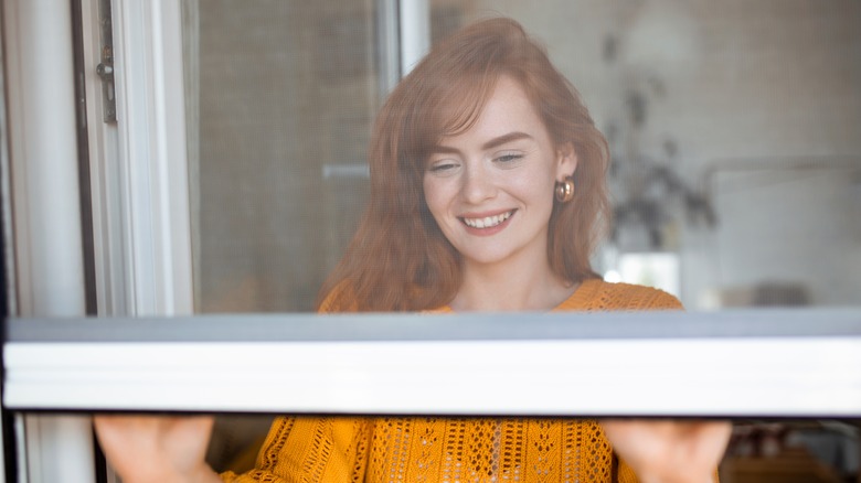 Woman closing window