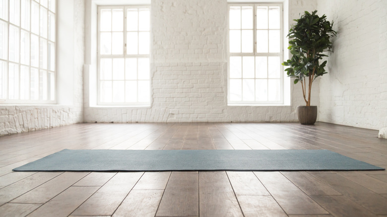 A yoga mat rolled out on a wood floor