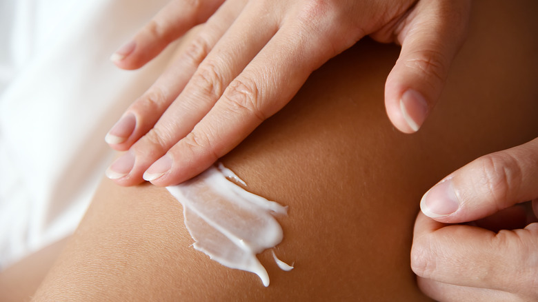 Woman applying ointment to skin 