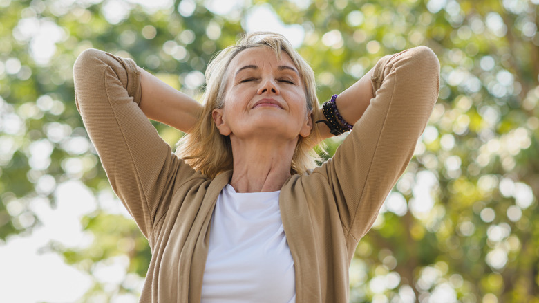 smiling woman standing nature eyes closed