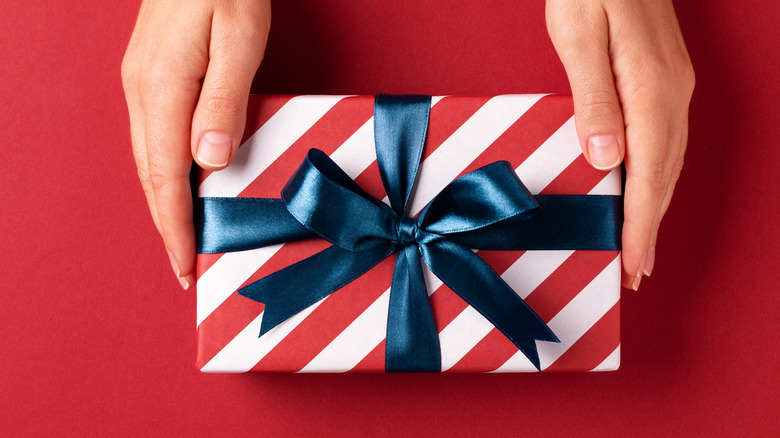 Woman holding a red and white wrapped gift