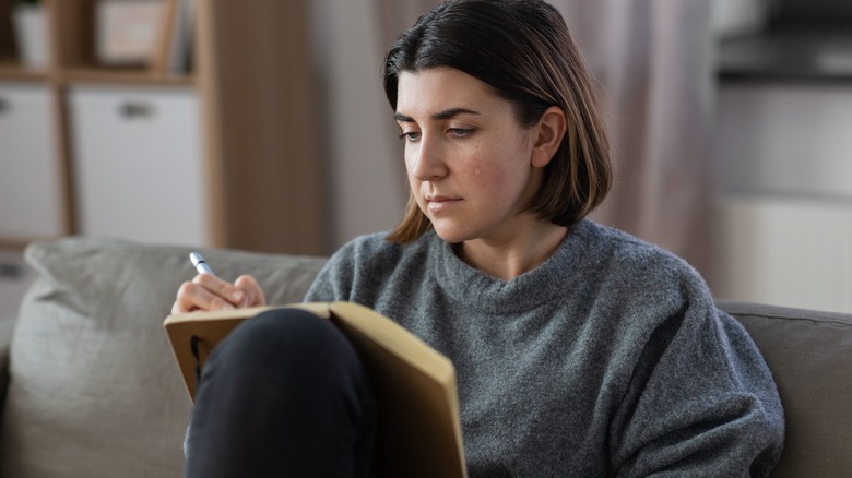 woman with tear journaling