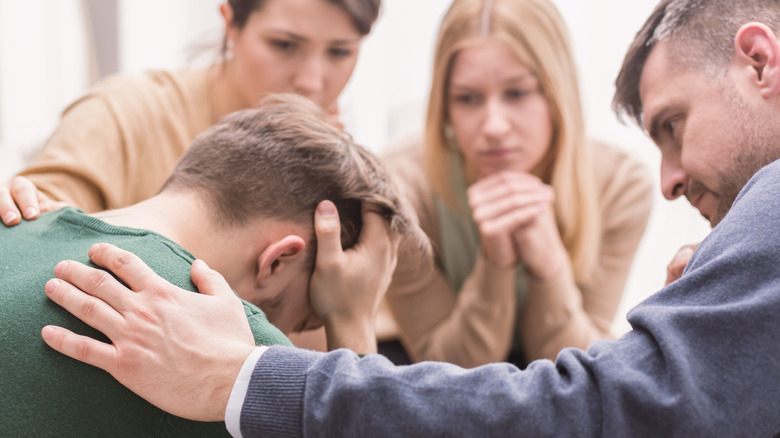 Friends helping upset man