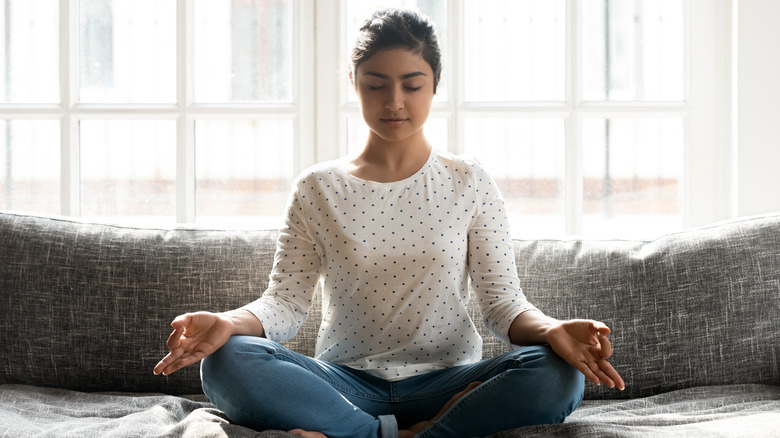 woman sitting on her couch with her eyes closed