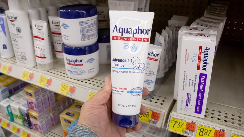 person holding tube of Aquaphor