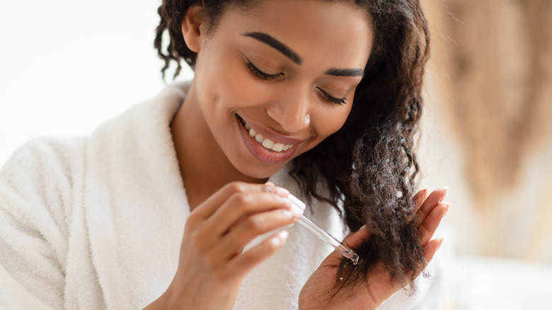 Woman putting hair oil in her hair