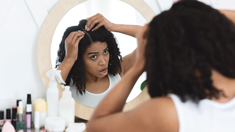 Woman inspecting her hair