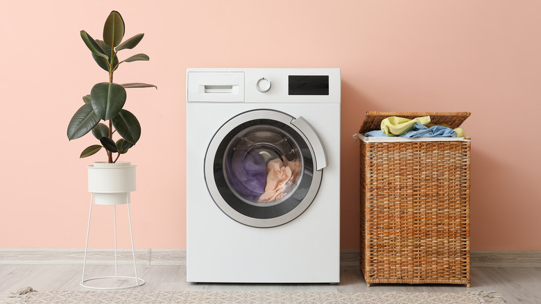 Washing machine next to a clothing hamper