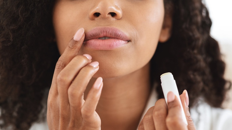 Woman applying lip balm