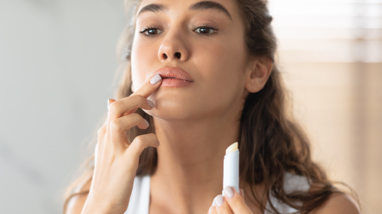 Woman applying lip balm