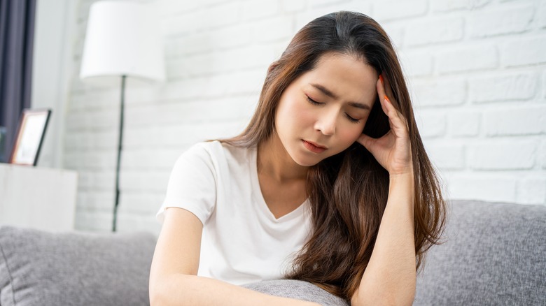 An upset woman sitting on a couch. 