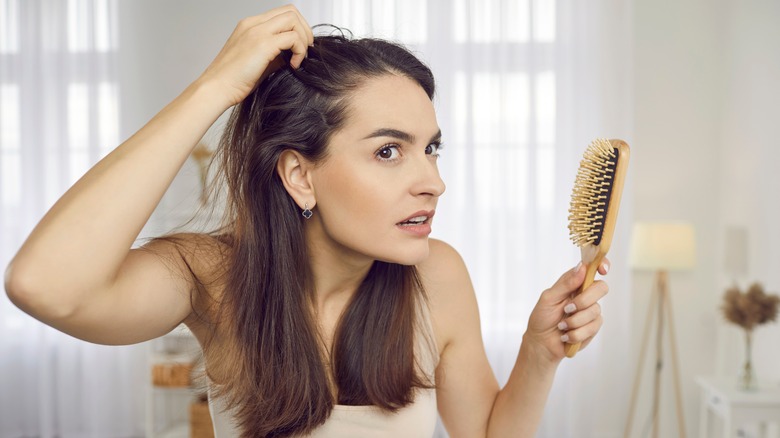 Woman looking at her hair in the mirror