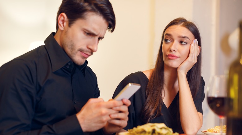 Woman on a bad date with man on his phone