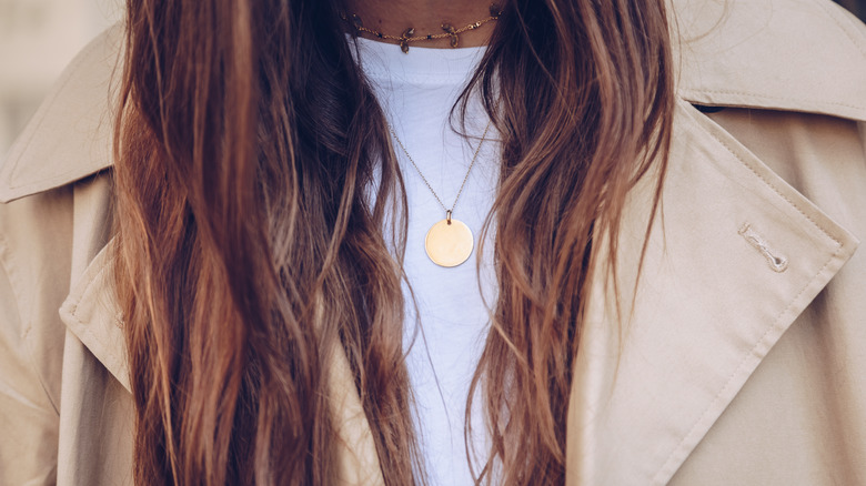 Woman wearing layered necklaces with a t-shirt and jacket