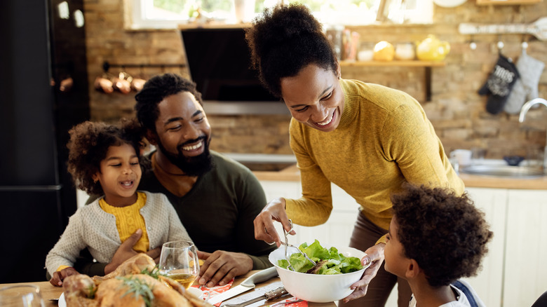 young family smiling at dinner table