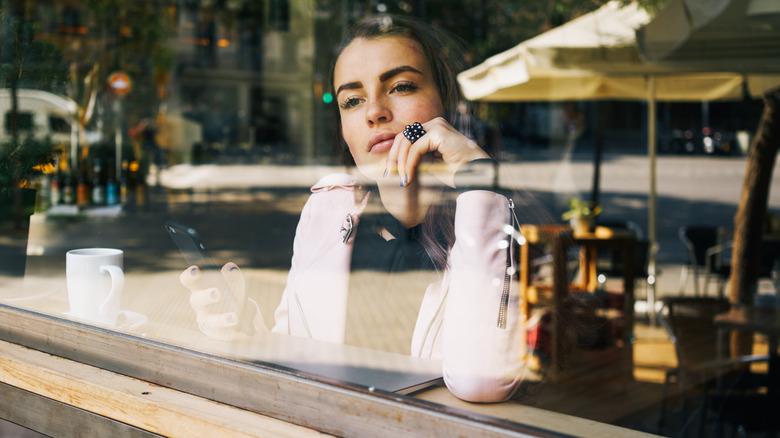 woman thinking while holding phone