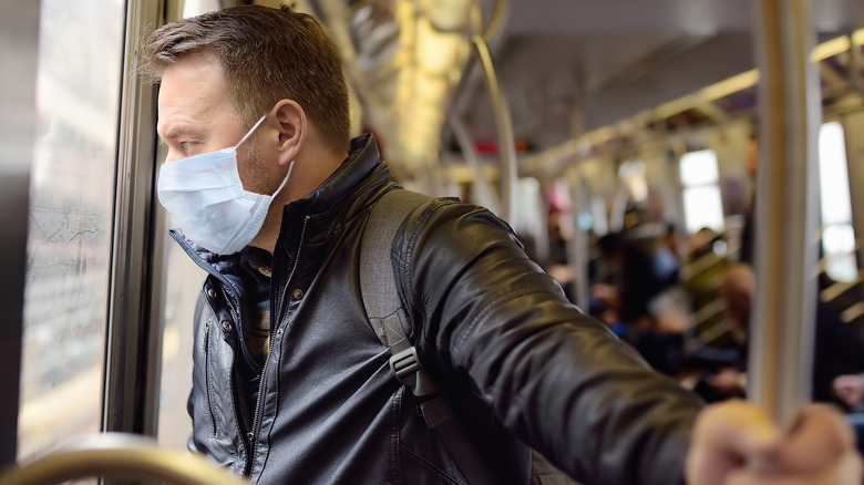 Man in mask taking public transport