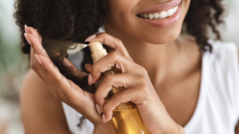 Woman spraying hair product into her hair