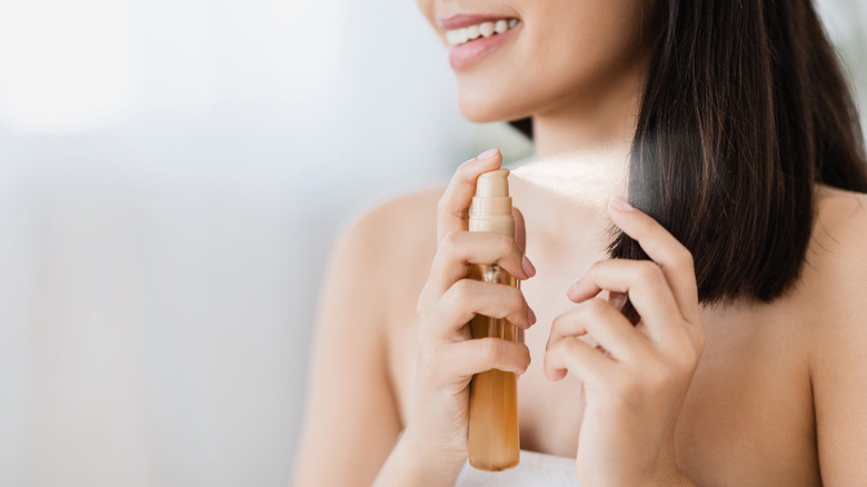 Woman spraying her hair with hair product