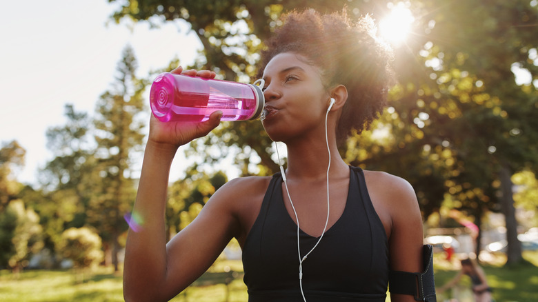 Woman drinking from a reusable water bottle