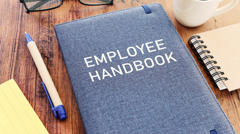 employee handbook and supplies on desk
