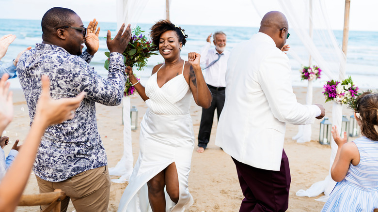 Bride and groom and guests at beach wedding