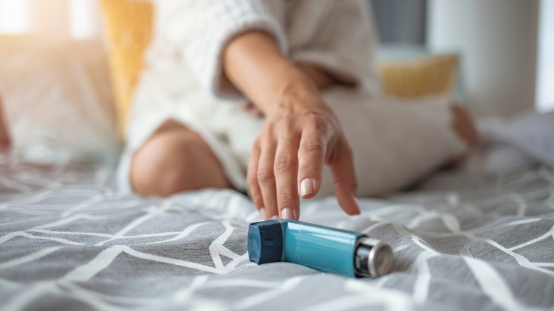 Woman on bed with inhaler