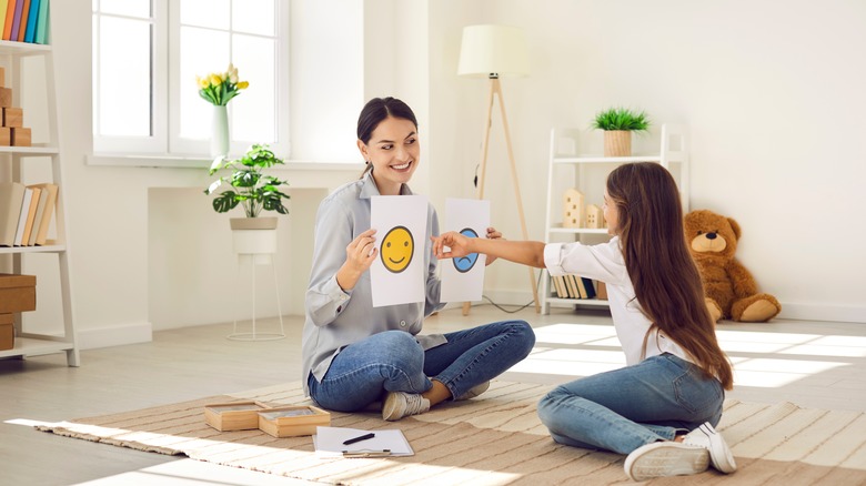 girl pointing at smiley face card