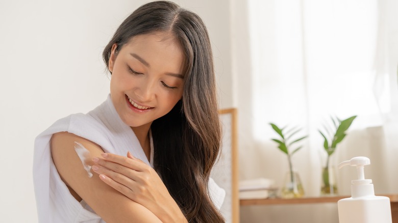 Woman putting on moisturizer