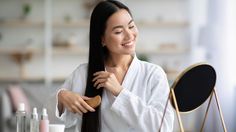 A woman happily brushing her smooth hair