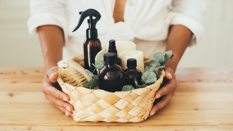 woman holding basket with laundry spray bottles