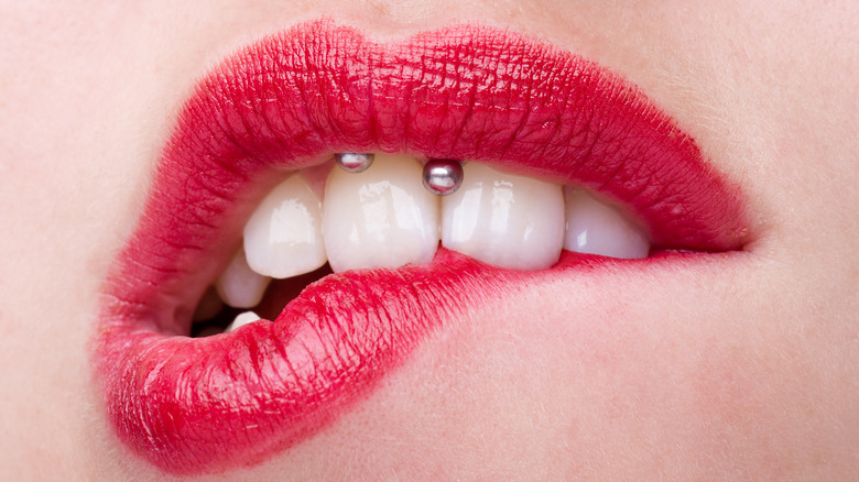 woman with smiley piercing biting lip