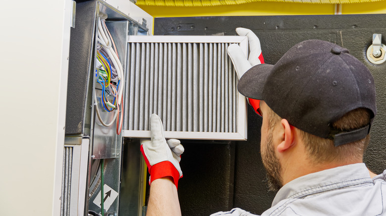 HVAC technician changes furnace filter