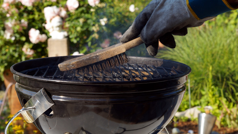 person cleans a grill 