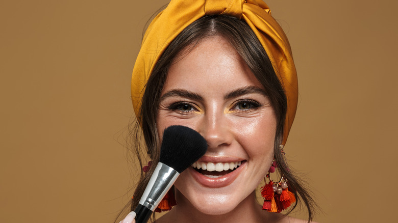 Woman smiling with makup brush