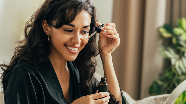 A woman applying skincare product to her face. 