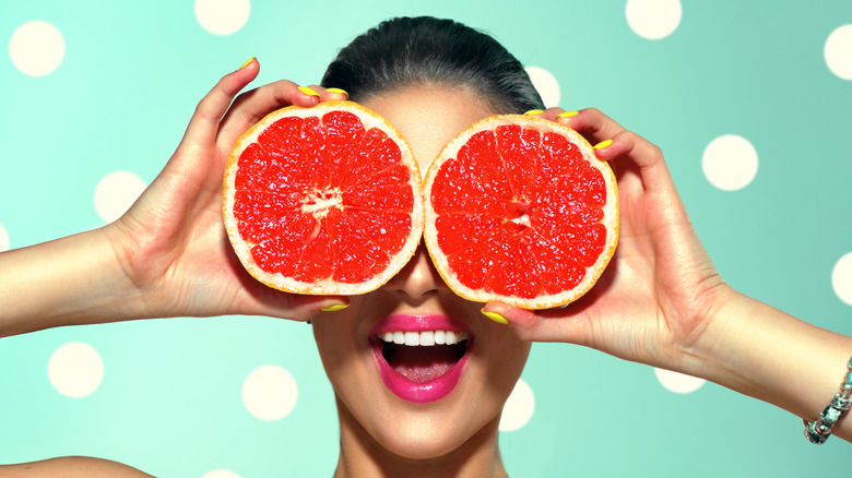 woman holding grapefruit