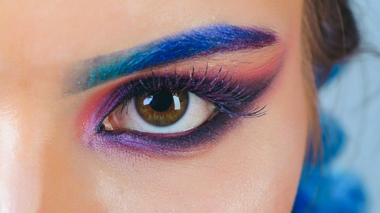 person with bold eyeshadow and colorful eyebrows