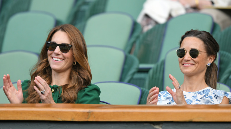 Kate and Pippa Middleton smiling and clapping