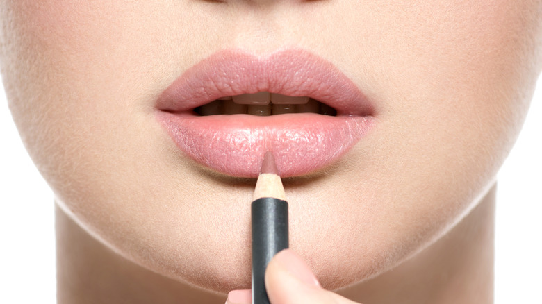 woman applying lip liner 