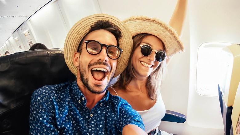 Two happy tourists on a plane 